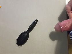 Jerking off on a small hairbrush, cumshot with a lot of cum from a big cock by an handjob.